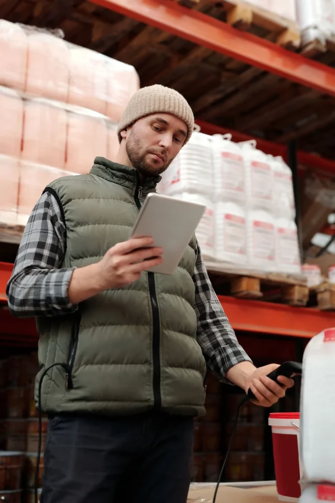 Empleado contando inventario con una tableta en una bodega
